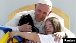 El papa Francisco abraza a dos jóvenes con síndrome Down en el estadio José María Pavón de Morelia.