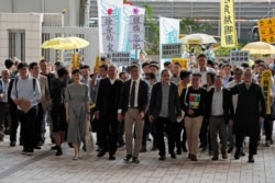 FILE - Occupy Central leaders from right; Shiu Ka Chun, Lee Wing Tat, Raphael Wong, Benny Tai, Chan Kin-man, Chu Yiu-ming, Tanya Chan, Eason Chung and Tommy Cheung arrive a court in Hong Kong, April 9, 2019.