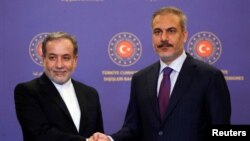 Iranian Foreign Minister Abbas Araqchi, left, shakes hands with his Turkish counterpart, Hakan Fidan, during a joint press conference in Istanbul on Oct. 19, 2024.