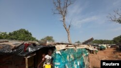 FILE - A girl carries a baby on her back at the Kuchingoro internally displaced persons camp, as the government works to contain the spread of COVID-19 in Abuja, Nigeria, June 20, 2020. 