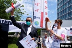 Generalni direktor Svjetske zdravstvene organizacije (WHO) Tedros Adhanom Ghebreyesus drži pismo koje mu je predao član doktora za XR (pobunu protiv izumiranja) u kojem ga poziva da poduzme mjere u vezi s klimatskim promjenama, u Ženevi, Švicarska, 29. maja 2021. godine.