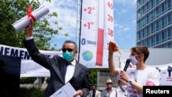 World Health Organization (WHO) Director General Tedros Adhanom Ghebreyesus holds a letter which was presented to him by a member of Doctors for XR (Extinction Rebellion) urging him to take action on climate change, in Geneva, Switzerland, May 29, 2021.