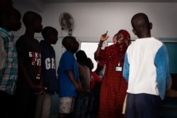 Talibés who were abused by their teachers learn the Koran from teacher Ya Seyda Fatoumata Diof at a shelter Dec. 12, 2019, in Dakar, Senegal. (Annika Hammerschlag/VOA)