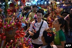 People buy dragon puppets on Yaowarat Road in Bangkok's Chinatown on Feb. 9, 2024, on the eve of the Lunar New Year.