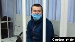 Belarusian blogger Vadzim Ermashuk is seen in a defendant's cage during court proceedings against him in this Svaboda.org reader-submitted courtesy photo. 