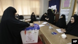 An Iranian woman casts her ballot for the parliamentary runoff elections, in a polling station, in Tehran, Iran, May 4, 2012.
