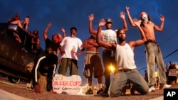 Manifestantes protestan en Ferguson con las manos arriba.