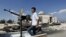 A Free Syrian Army soldier drives by a Syrian tank and a mosque, which were destroyed during fighting with government forces, in Azaz, on the outskirts of Aleppo, Sept. 23, 2012. 