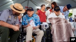 Pearl Harbor survivors, Ken Stevens, 102, of Powers, Ore., second from the left, and Ira 'Ike' Schab, 104, of Beaverton, Ore., wait before the start of the 83rd Pearl Harbor Remembrance Day ceremony, Dec. 7, 2024, in Honolulu. 