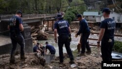 Fire and Rescue members set up a ladder to go down on Broad River riverbank, following the passing of Hurricane Helene, in Bat Cave, North Carolina, September 30, 2024.