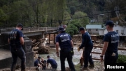 Anggota tim evakuasi tampak menyusun tangga yang mengarah ke area tepi Sungai Broad di Bat Cave, North Carolina, pada 30 September 2024, menyusul terjangan badai Helene ke wilayah tersebut. (Foto: Reuters/Marco Bello)