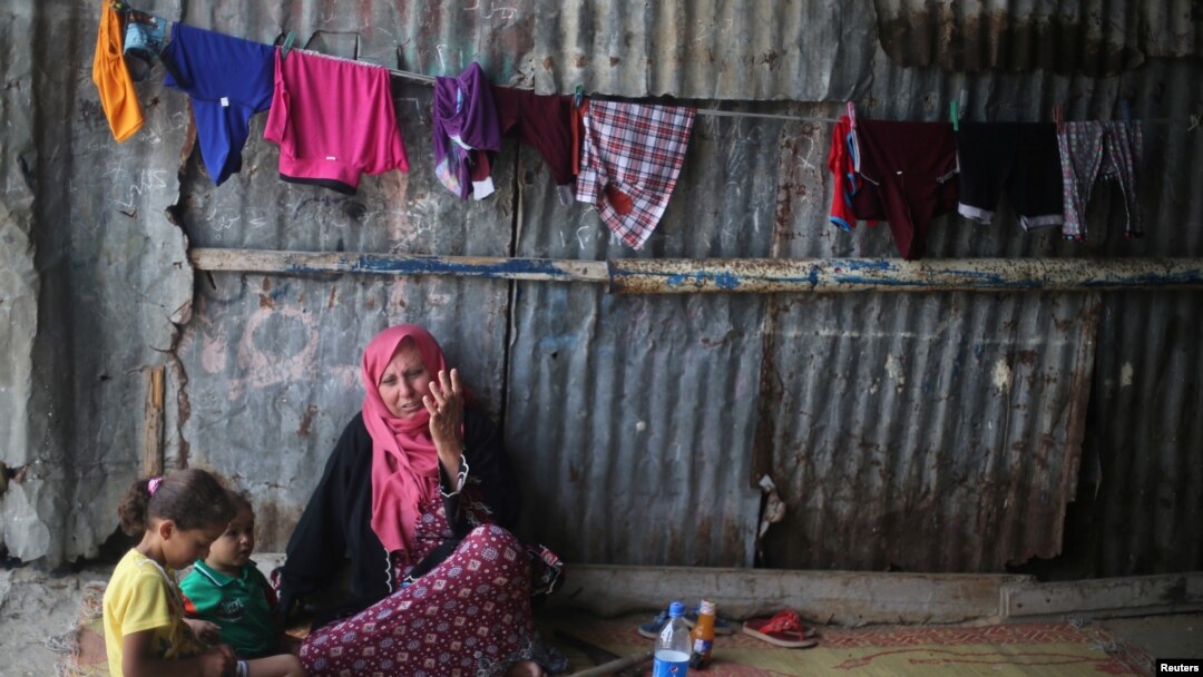 Seorang wanita Palestina duduk dengan cucunya di kamp pengungsi Khan Younis di Jalur Gaza selatan, 11 Juli 2017.
