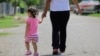 FILE - In this Sept. 16, 2015, photo, a woman in Sullivan City, Texas, who says she entered the country illegally, walks with her daughter, who was born in the U.S. A federal judge on Feb. 5, 2025, paused an executive order trying to end birthright citizenship.