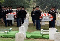 FILE - An Army honor guard carries the caskets of Julian Bartley Jr., left, and his father Julian Bartley Sr. during funeral services at Arlington National Cemetery in Arlington, Va., Aug. 18, 1998.