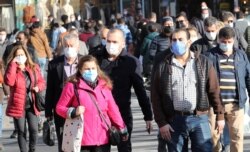 Pedestrians wearing face masks walk in Ankara on Nov. 13, 2020, amid the COVID-19 pandemic, caused by the novel coronavirus. Turkey made wearing masks in public areas mandatory in September.