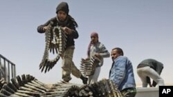 Libyan rebel fighters load a truck with ammunition on the outskirts of Ajdabiya, Libya, Saturday, April 16, 2011.