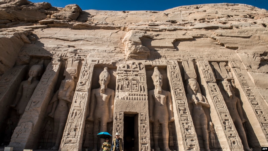 FILE - Tourists exit the Nefertari complex at the ancient Egyptian temple of Abu Simbel, Nov. 25, 2017, some 1,120 kilometers south of the Egyptian capital Cairo. The UNESCO World Heritage Site temples, originally carved out of the rocky mountainside during the reign of the 19th dynasty in the 13th century BC, were relocated to higher ground in 1968 on an artificial hill made from a domed structure to avoid being flooded during the creation of the Lake Nasser reservoir as the Aswan High Dam was being built.