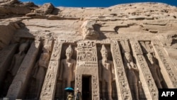 FILE - Tourists exit the Nefertari complex at the ancient Egyptian temple of Abu Simbel, Nov. 25, 2017, some 1,120 kilometers south of the Egyptian capital Cairo. The UNESCO World Heritage Site temples, originally carved out of the rocky mountainside during the reign of the 19th dynasty in the 13th century BC, were relocated to higher ground in 1968 on an artificial hill made from a domed structure to avoid being flooded during the creation of the Lake Nasser reservoir as the Aswan High Dam was being built.