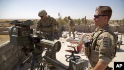 FILE - In this Aug. 20, 2017, file photo, U.S. Army soldiers stand next to a guided-missile launcher, a few miles from the front line, in the village of Abu Ghaddur, east of Tal Afar, Iraq. 