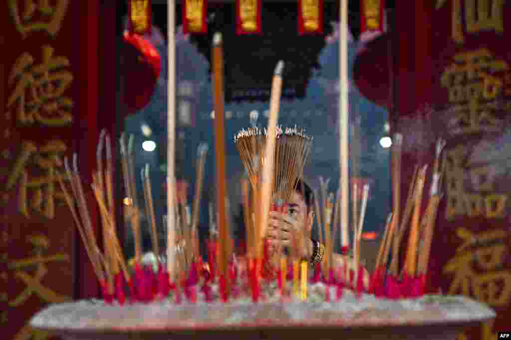 An ethnic Malaysian Chinese man burns incense as he offers prayers on the first day of the Lunar New Year of the Snake at Kwong Fook Temple in Bentong, Malaysia&#39;s Pahang state.