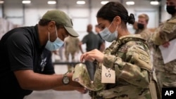 In this image provided by the U.S. Army, Sgt. Katiushka Rivera, a soldier assigned to the 82nd Airborne gets fitted for a modular scalable vest (MSV) during a fielding event in Fort Bragg, N.C., on Sept. 13, 2021.