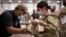 In this image provided by the U.S. Army, Sgt. Katiushka Rivera, a soldier assigned to the 82nd Airborne gets fitted for a modular scalable vest (MSV) during a fielding event in Fort Bragg, N.C., on Sept. 13, 2021.