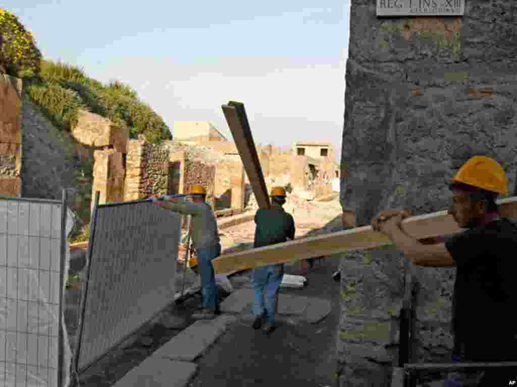 Workers repair the 2,000-year-old "House of the Gladiators" in the ruins of ancient Pompeii. (Reuters)