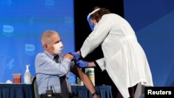 Dr. Anthony Fauci, director of the National Institute of Allergy and Infectious Diseases, receives his first dose of the new Moderna COVID-19 vaccine at the National Institutes of Health, in Bethesda…