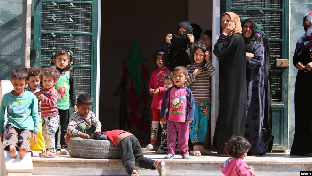 Para perempuan dan anak-anak Suriah kembali ke rumah mereka di Manbij, Aleppo setelah ISIS mundur dari kota ini. 