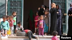 Para perempuan dan anak-anak Suriah kembali ke rumah mereka di Manbij, Aleppo setelah ISIS mundur dari kota ini. 