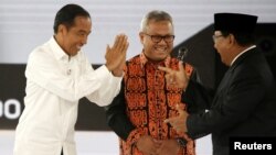 Presiden Joko Widodo menyambut capres Prabowo Subianto disaksikan oleh Ketua Komisi Pemilihan Umum Arief Budiman dalam debat capres/cawapres pemilu 2019 di Jakarta, 30 Maret 2019. (Foto: Reuters)