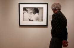 FILE - A man looks at a print from the Looking In: Robert Frank's "The Americans" exhibit at the Museum of Modern Art in San Francisco, May 18, 2009.