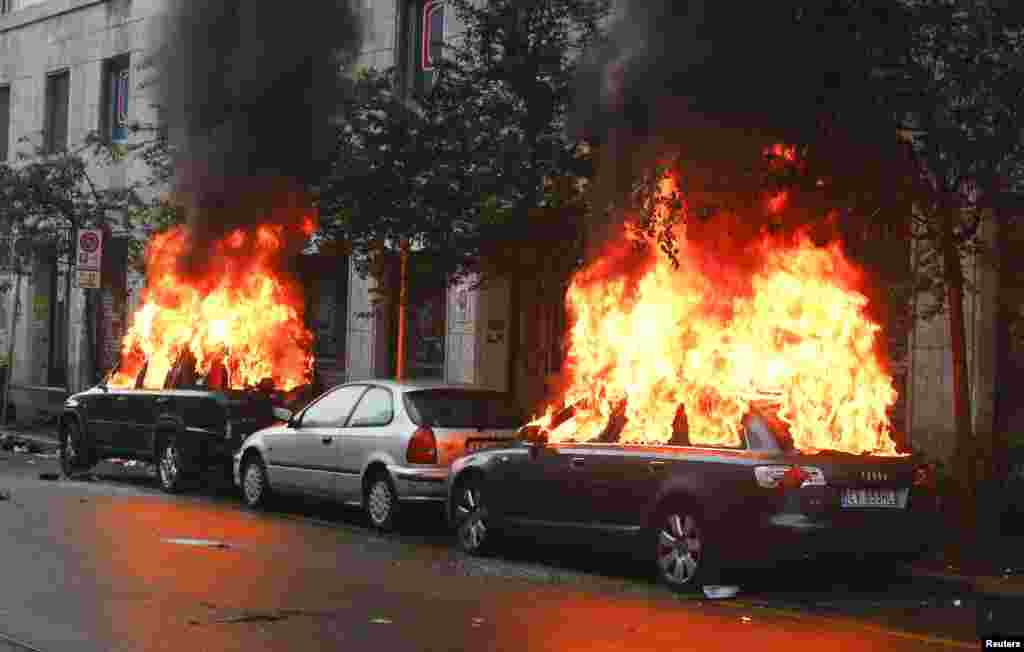 Cars are set on fire by protesters during a rally against Expo 2015 in Milan, Italy. Italy opened the Expo on Friday, torn between hopes that the showcase of global culture and technology will cheer up a gloomy national mood and fears that it will be overshadowed by scandal, delays and street protests.