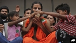 Baba Ramdev (tengah) guru yoga terkenal di India mengakhiri mogok makan 6 hari dengan minum segelas sari buah, namun bertekad terus berjuang melawan korupsi (14/8). 