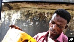 A roadside vendor pours fuel into a bottle in Lome (File)