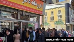 مشتریان برای دریافت داروی مورد نیاز خود مقابل یک داروخانه صف کشیده اند