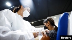 A woman receives a dose of the Moderna vaccine against the COVID-19 at the Music Auditorium in Rome, Italy, Aug. 5, 2021. 
