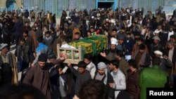 FILE - Afghan men attend a funeral ceremony of an International Committee of the Red Cross (ICRC) employee, who was killed by gunmen in Mazar-i-Sharif, Afghanistan, Feb. 9, 2017.