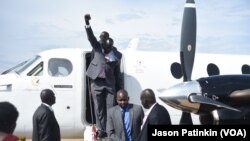 Second-in-command of South Sudan's rebels, Alfred Lado Gore, raises his fist after landing in the capital Juba, after more than two years in exile, April 12, 2016. Rebel leader Riek Machar is scheduled to return on April 18. 
