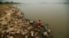 Personas pescan en las orillas del río Paraguay, que alcanzó bajos niveles récord de agua debido a una fuerte sequía. En Villeta, Paraguay, el 7 de septiembre de 2024.