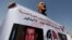 FILE - A man whose relatives were killed during the 2011 Egyptian revolution holds a banner with pictures of former President Hosni Mubarak, Sept. 27, 2014.