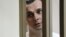 Oleh Sentsov stands behind glass in a cage at a courtroom in Rostov-on-Don, Russia, July 21, 2015.