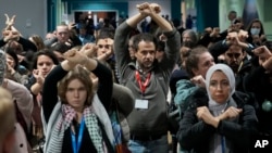 Activists demonstrate in silence as they protest a proposed deal for providing billions of dollars to developing nations to help offset the effects of climate change, at the COP29 U.N. Climate Summit, on Nov. 22, 2024, in Baku, Azerbaijan.