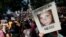 FILE - A protester holds up a photo of Heather Heyer at a "Free Speech" rally in Boston, Massachusetts. Heyer was killed when a car, driven by James Alex Fields Jr., plowed into a group of people during protests Charlottesville, Virginia.