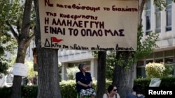  Supporters of the employees of state broadcaster ERT sit outside its headquarters in Athens, June 17, 2013.