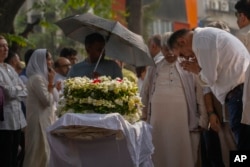 Bollywood actor Boman Irani, right, pays homage to Shyam Benegal, a renowned Indian filmmaker who passed away on Monday, during Benegal's funeral in Mumbai, Dec. 24, 2024.