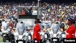 Kenya's out-going President Uhuru Kenyatta wavs to his supporters as he arrives for the swearing-in ceremony of the in-coming President William Ruto in Nairobi