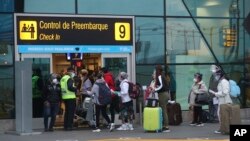 Penumpang mengenakan masker saat antre untuk check-in di Bandara Internasional Jorge Chávez, Callao, Peru, di tengah pandemi Covid-19, Rabu, 15 Juli 2020.