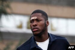 FILE - French youth worker Theo Luhaka, arrives to address people during a rally against police violence organised by the "Justice for Theo" group, outside the courthouse of Bobigny, near Paris, on October 28, 2017.