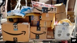 Des cartons Amazon Prime sont chargées sur un chariot pour livraison à New York, le 10 octobre 2018.
